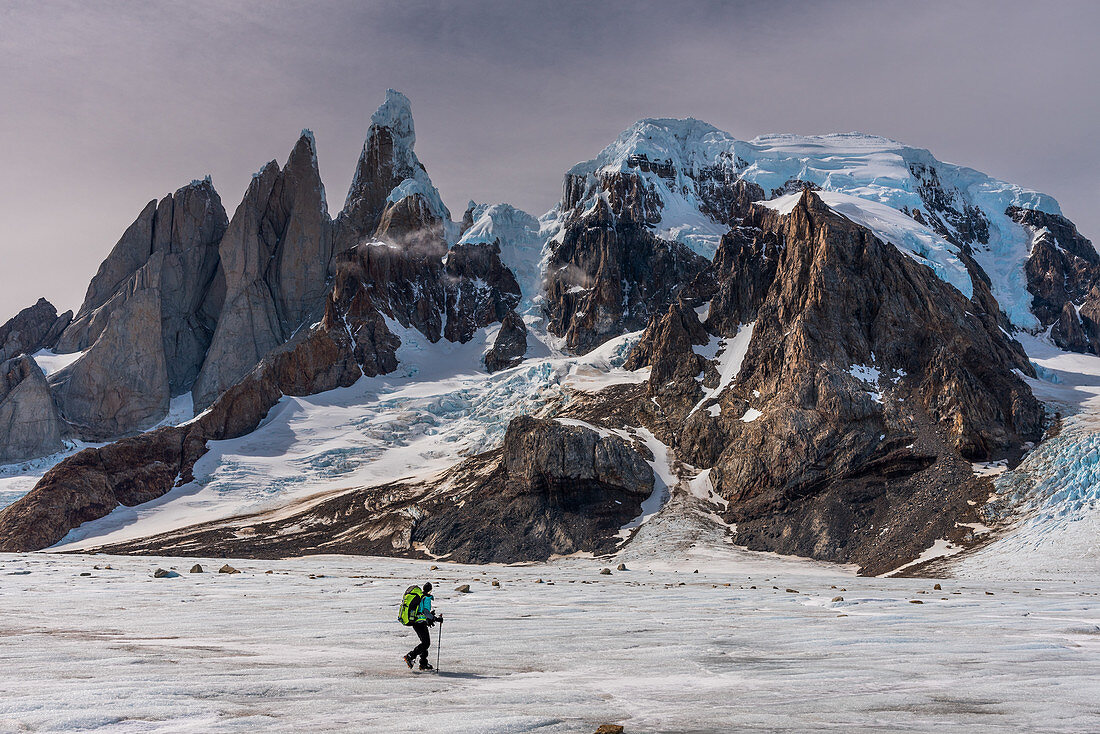 Mountaineer on ice surface in front of Circo de los Altares looks out over Cerro Torre,, Los Glaciares National Park, Patagonia, Argentina