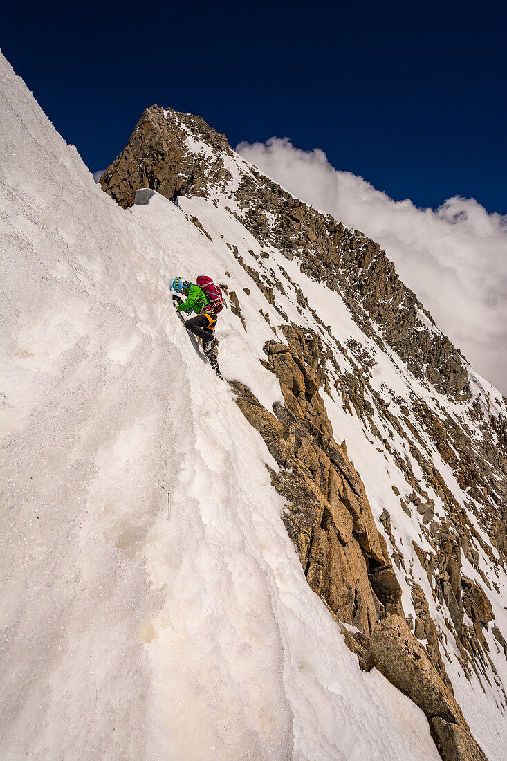 Bergsteigerin beim Klettern an den Grandes Jorasses, Nassschnee am Fels, Mont Blanc-Gruppe, Frankreich