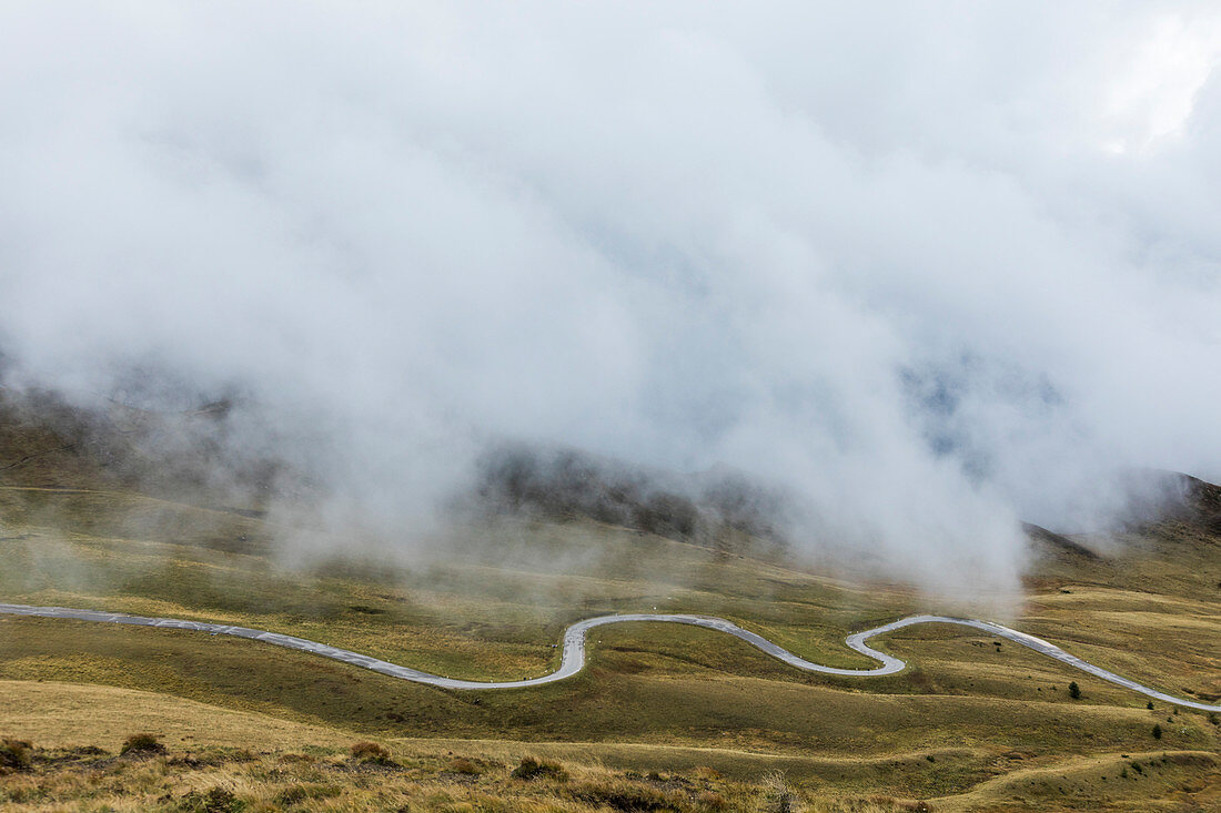 Winding road under fog at Giau Pass in Italy