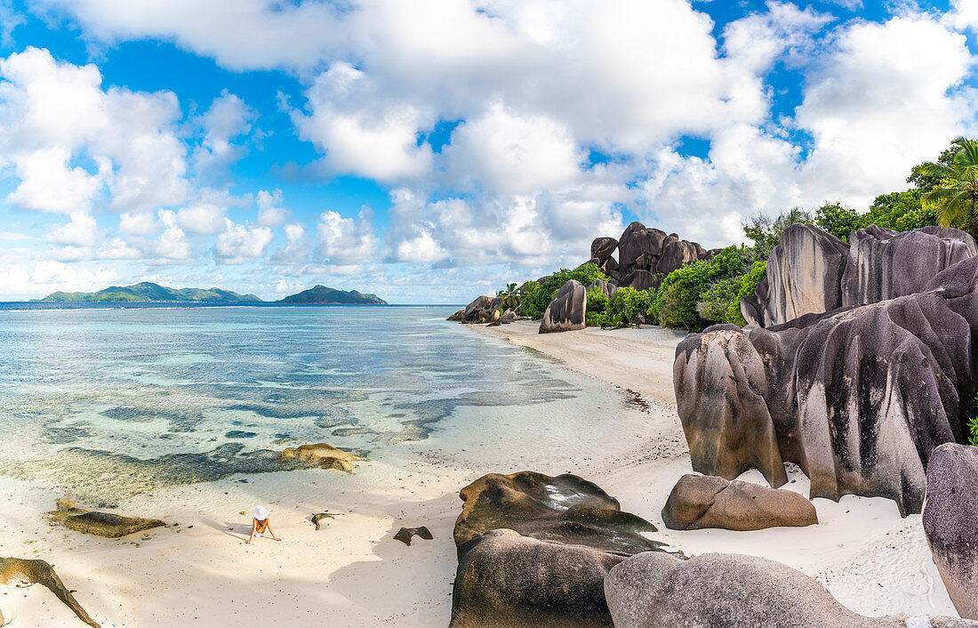 Junge Frau, die sich am Strand von Anse Source d'Argent entspannt, Insel La Digue, Seychellen, Afrika