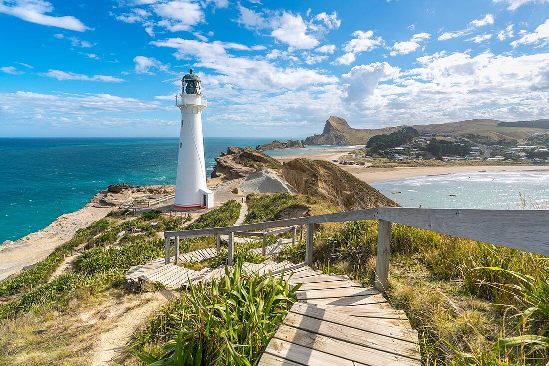 Castlepoint lighthouse and Castle Rock in the background. Castlepoint, Wairarapa region, North Island, New Zealand.