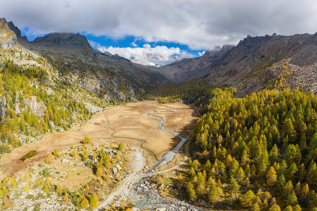 Aerial view of Preda Rossa valley and its stream, with granite peaks in the background. Val Masino, Sondrio province, Lombardy, Italy.
