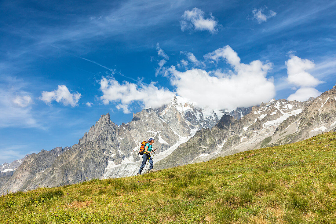 A trekker is walking in front of the Mont Blanc during the Mont Blanc hiking tours (Ferret Valley, Courmayeur, Aosta province, Aosta Valley, Italy, Europe) (MR)