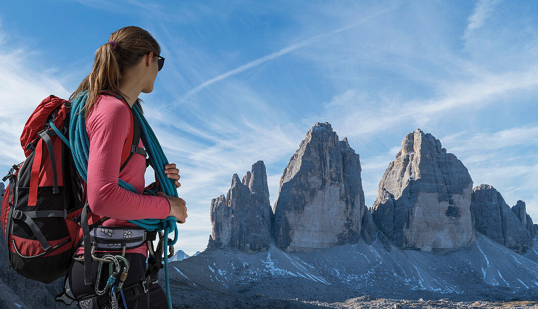 Woman with ropes looking at Tre Cime di Lavaredo in the Dolomites, Italy