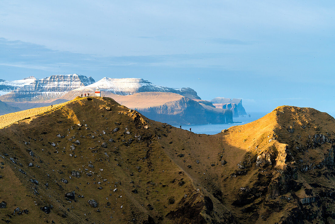 Hikers on crest towards Kallur lighthouse, Kalsoy island, Faroe Islands, Denmark