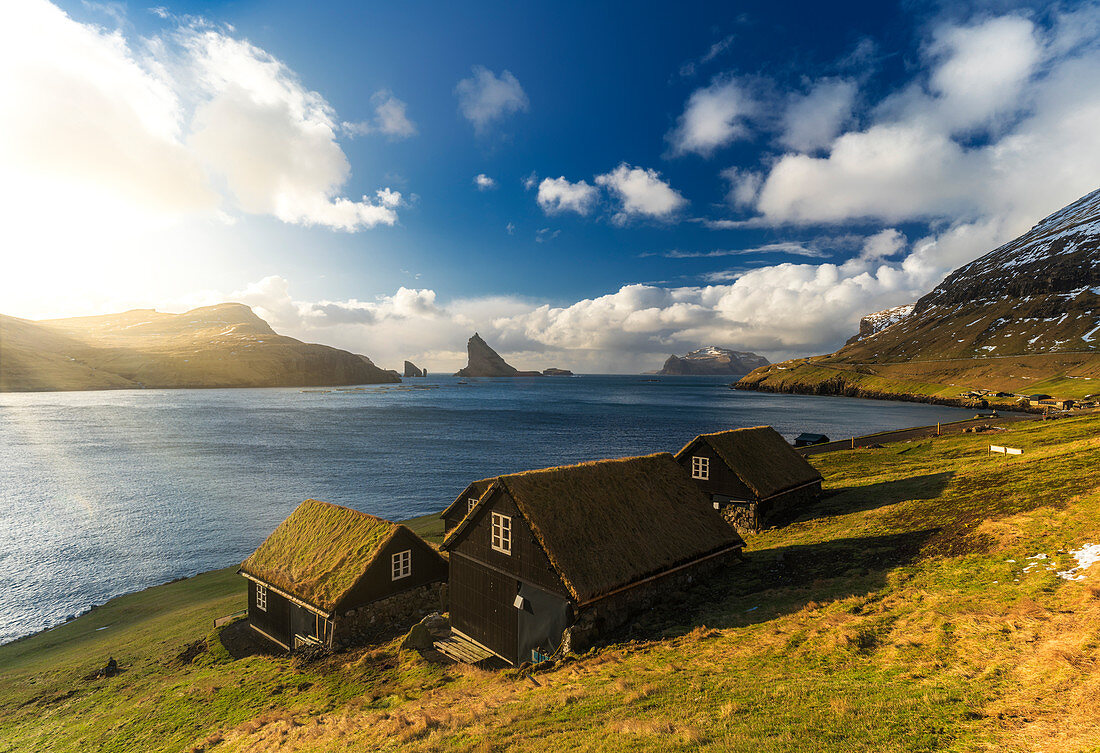Häuser mit Rasendach, Insel Drangarnir und Tindholmur im Hintergrund, Bour, Vagar-Insel, Färöer, Dänemark