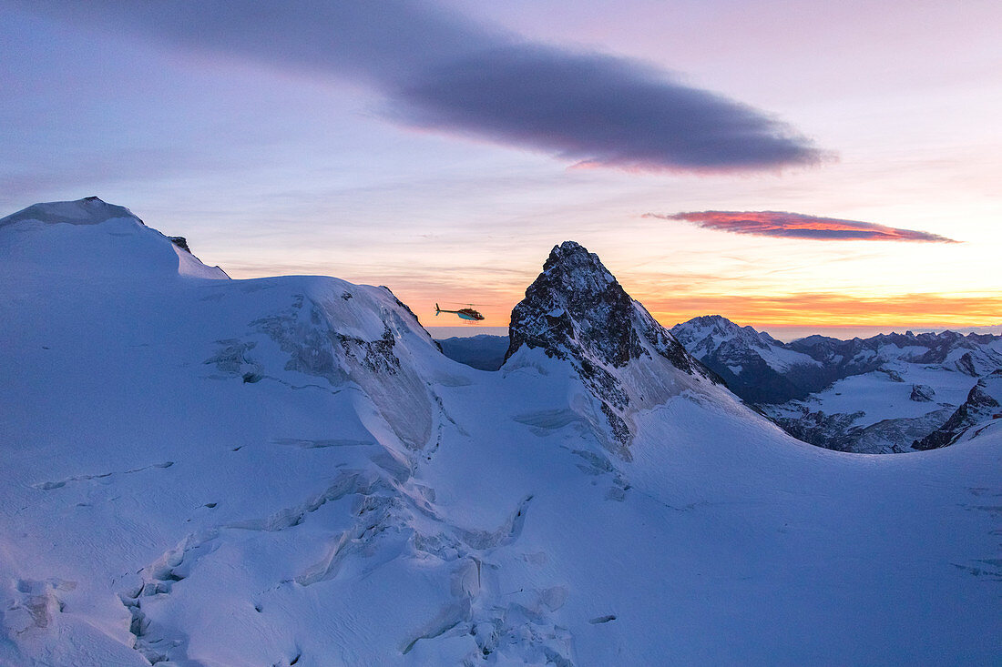 Hubschrauber übrt dem schneebedeckten Gipfel des Cresta Guzza in Richtung Piz Bernina, Valmalenco, Lombardei, Grenze zwischen Italien und der Schweiz