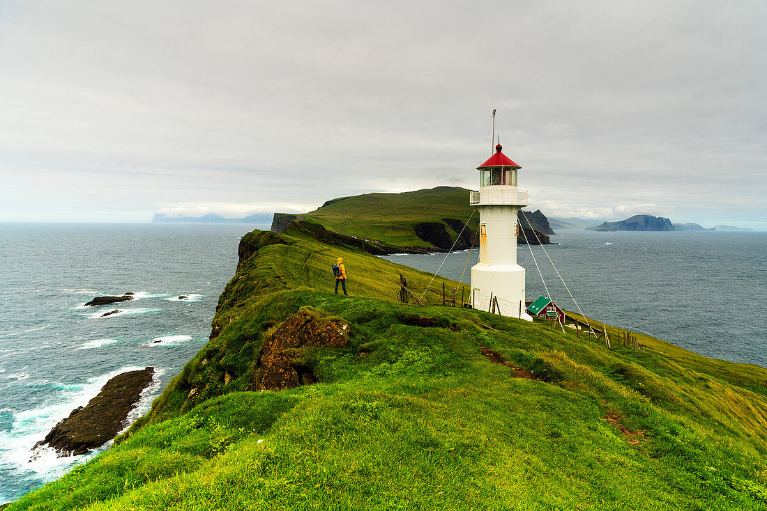 Hiker at the lighthouse, Mykines island, Faroe Islands, Denmark