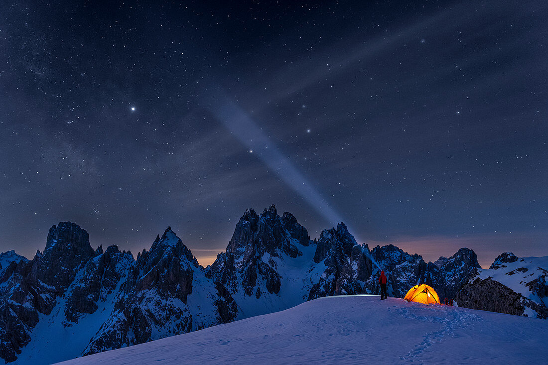 Mount Campedelle, Misurina, Auronzo di Cadore, province of Belluno, Veneto, Italy, Europe. A mountaineer admires the starry sky over the Cadini mountains