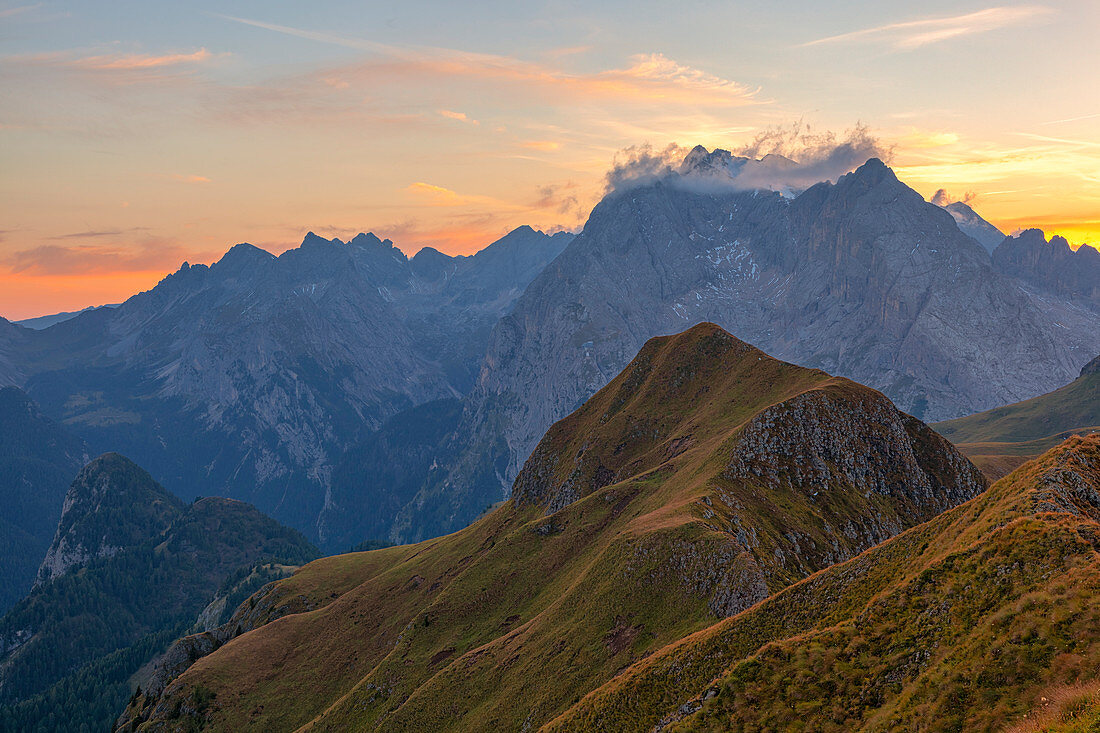 Sunset on the Marmolada Group seen from the grassy summit of Migogn Mount, Dolomites, Marmolada group, Rocca Pietore, Belluno province, Veneto, Italy.