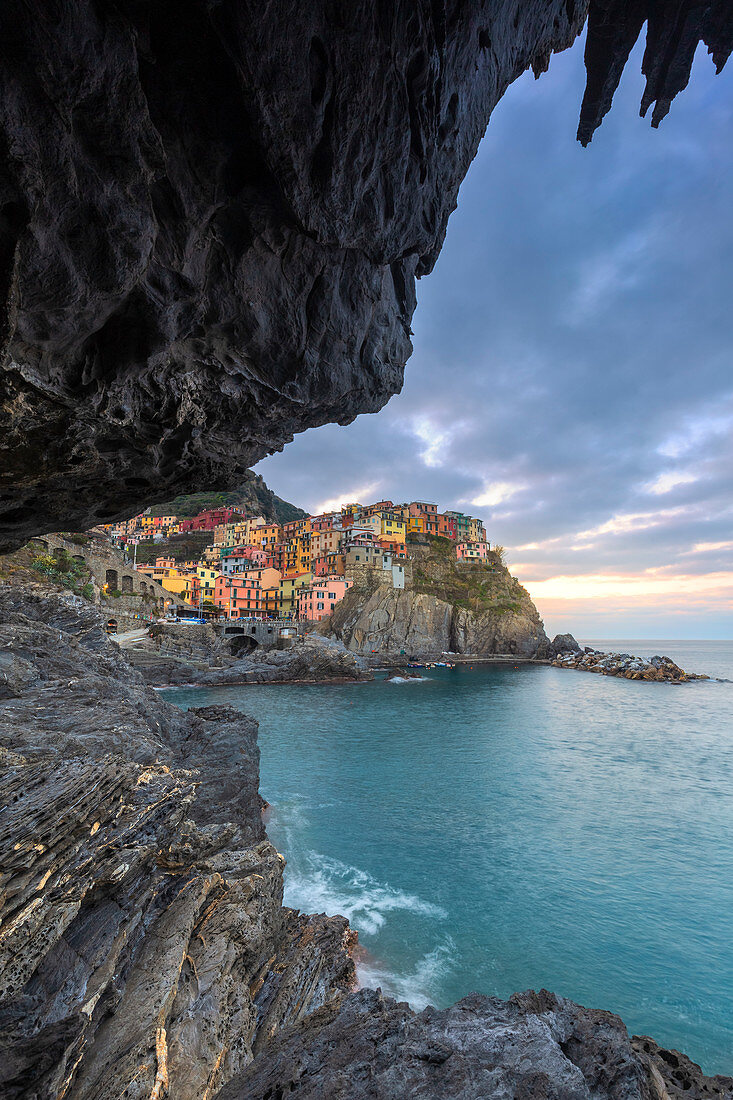 Sunrise on the village of Manarola from a sea cave. Cinque Terre, Liguria, Italy, Europe.