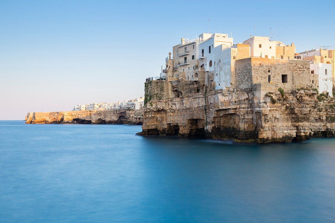 View of the overhanging houses of Polignano a Mare from the cliff in front of the town. Bari district, Apulia, Italy, Europe.