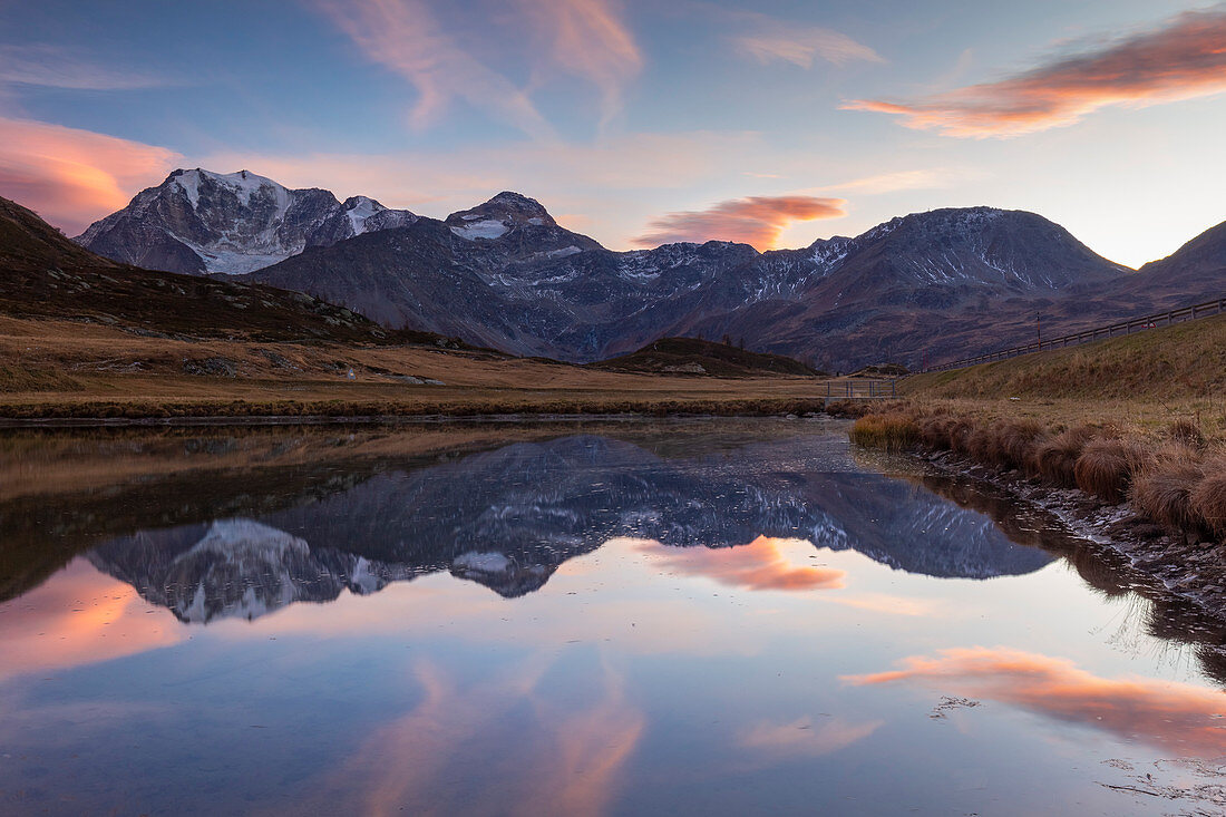 Reflection of the Fletschhorn in a small pond at the top of the Simplon pass at sunset. Simplonpass, Canton of Valais, Switzerland.