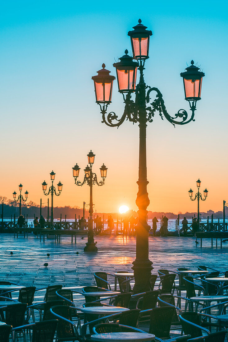 St Mark's square, Venice, Veneto, Italy. Tourists admiring the sunrise over St. Mark's waterfront.
