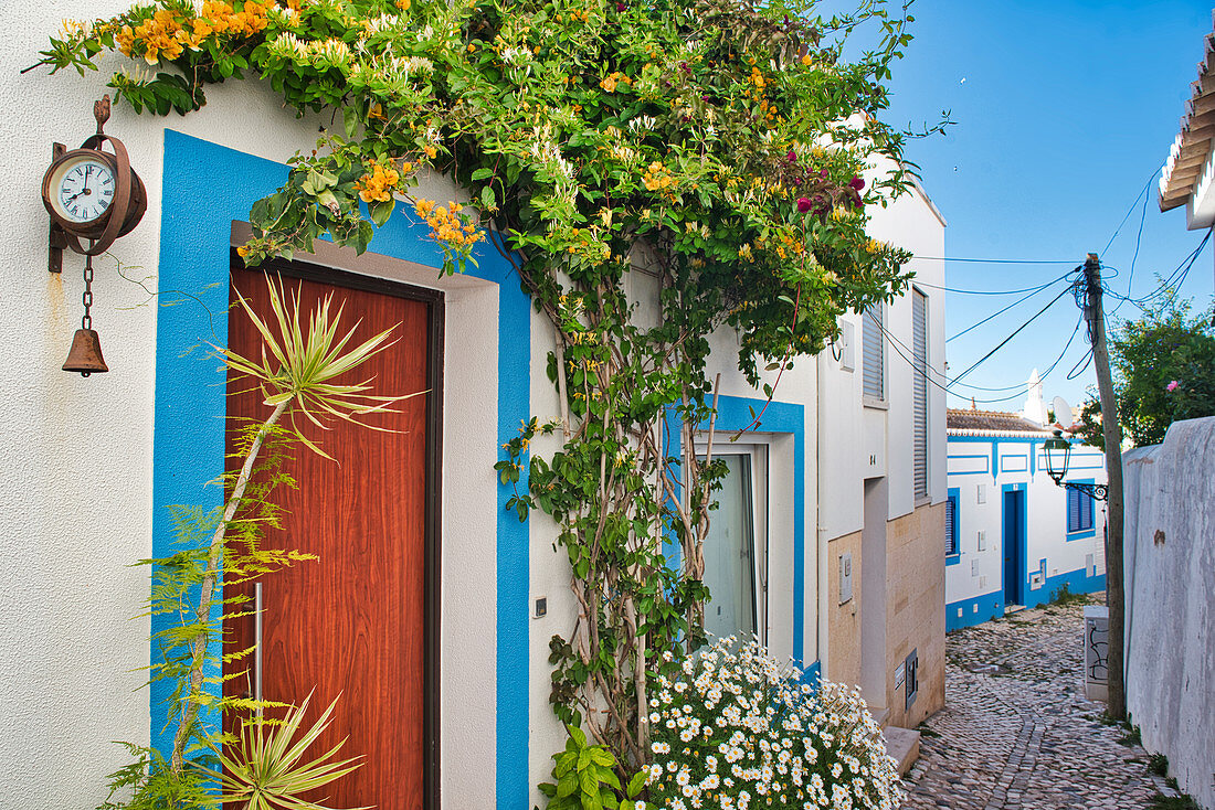 Enge Gasse in Ferragudo mit blühenden Pflanzen, Algarve, Portugal