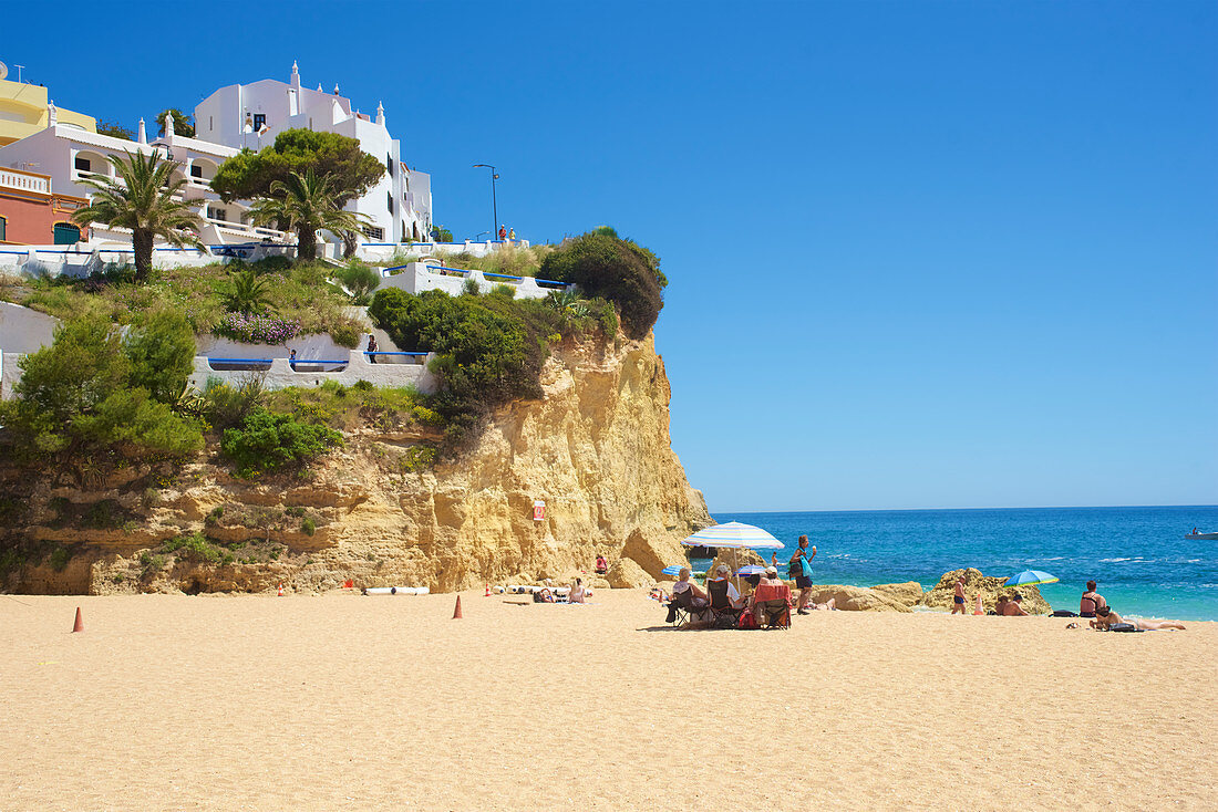 Wenige Menschen am Strand bei strahlend blauem Himmel in Carvoeiro, Lagoa, Algarve, Portugal