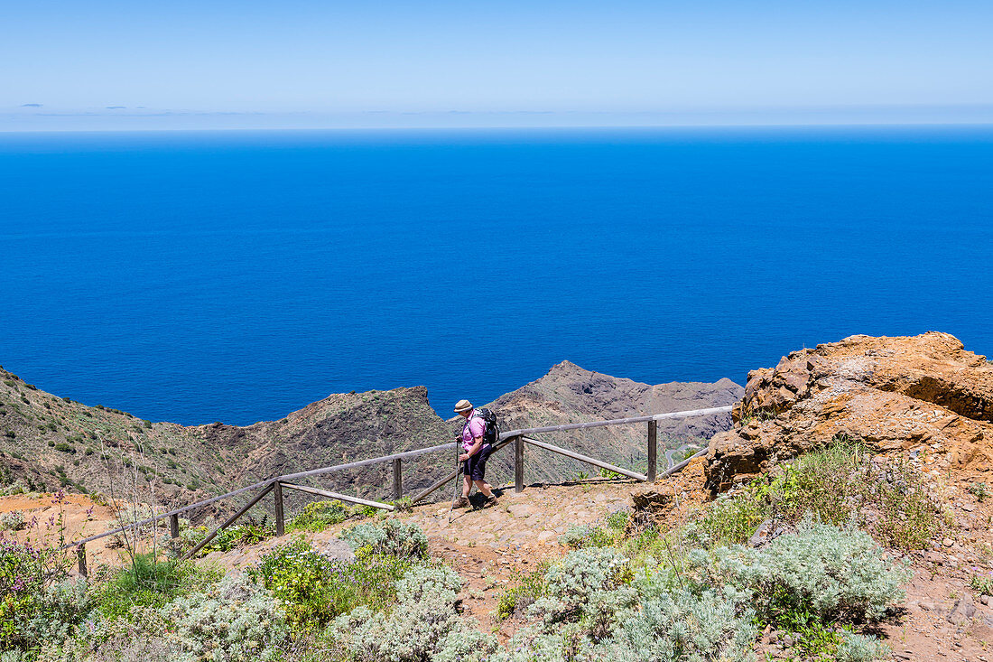 Eine Wanderin im Nationalpark Garajonay mit Blick auf den Atlantik, Agulo, La Gomera, Kanarische Inseln, Spanien
