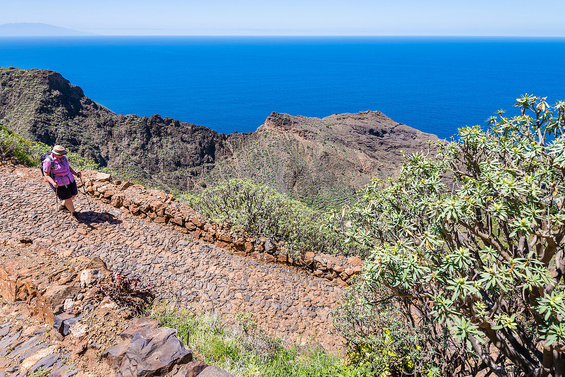 Eine Wanderin im Nationalpark Garajonay mit Blick auf den Atlantik, La Gomera, Kanarische Inseln, Spanien