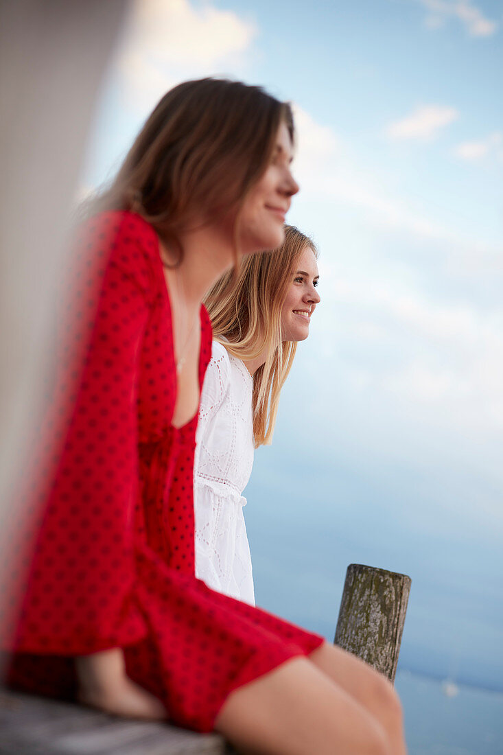 Zwei junge Frauen auf einem Steg, Ammerland, Starnberger See, Bayern, Deutschland