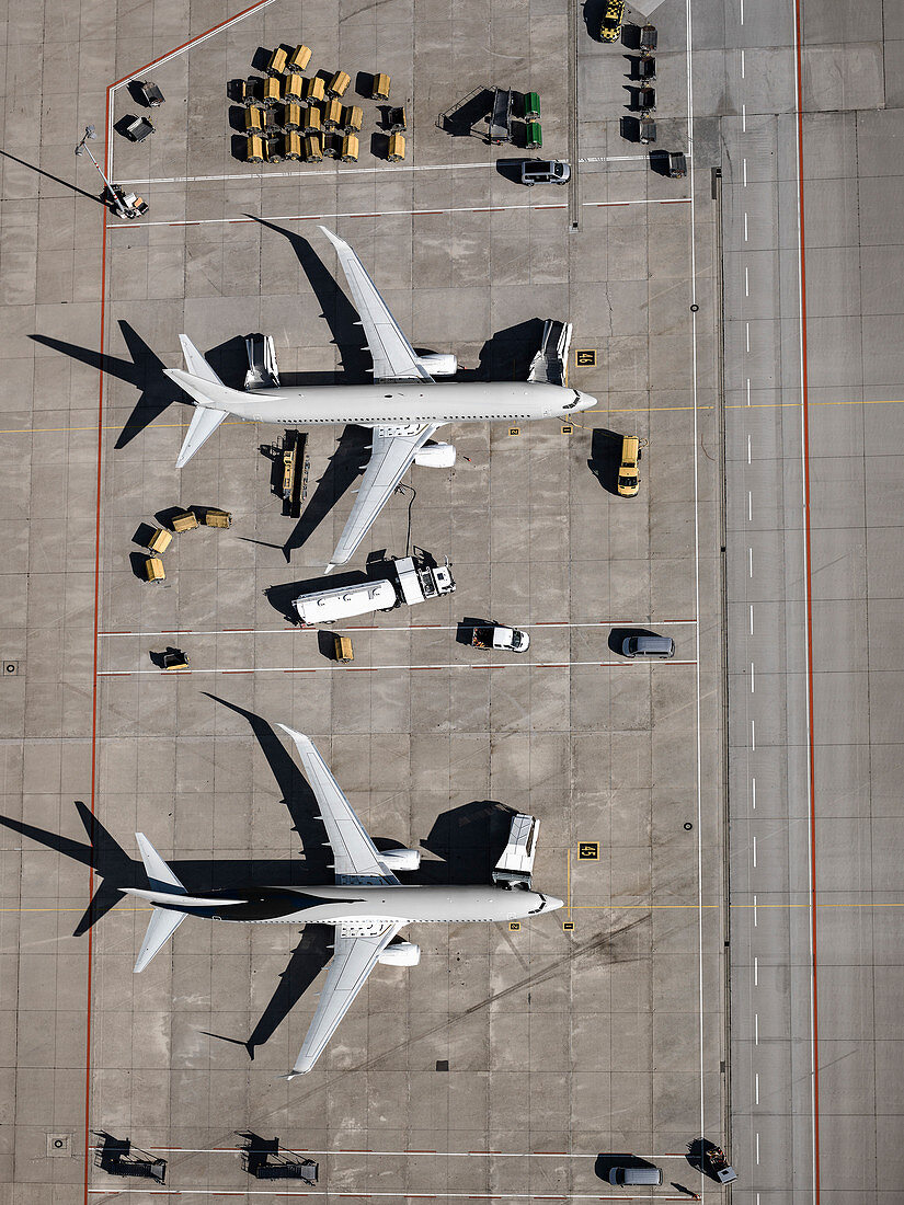 Aerial view commercial airplanes being serviced on tarmac at airport