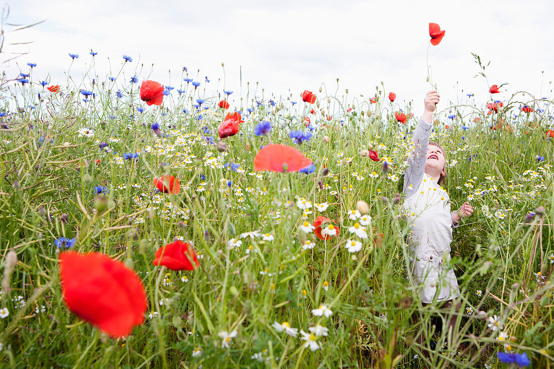 Girl playing in field of wildflowers