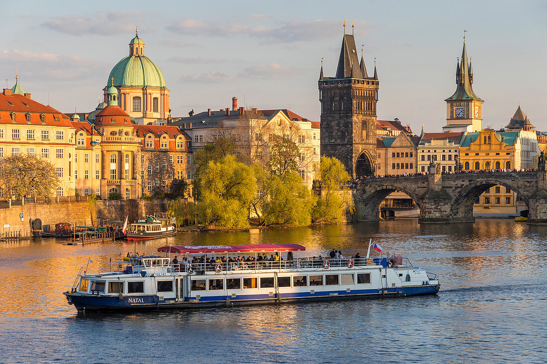 Touristisches Boot, bei der Karlsbrücke und dem alten Stadtbrückenturm auf der Moldau, Prag, Böhmen, Tschechische Republik, Europa
