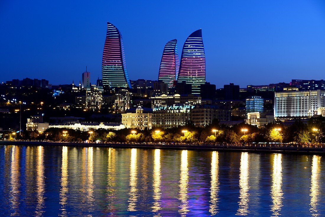 Evening view from the waterfront over Baku Bay to the Flame Towers with illumination, Baku, Caspian Sea, Azerbaijan, Asia