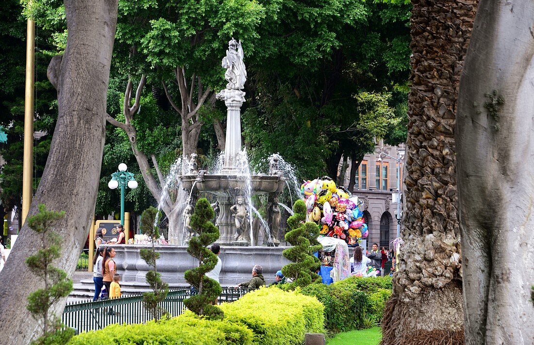 Fountain and balloon seller in the park at the Zocalo, Puebla, Mexico