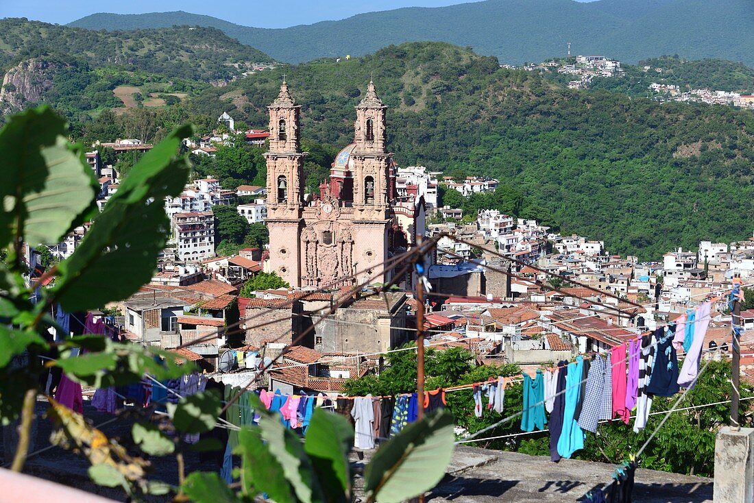 Blick über bunte Wäsche von oben auf die Altstadt und die Igleisia de Santa Prisca von Taxco, Mexiko