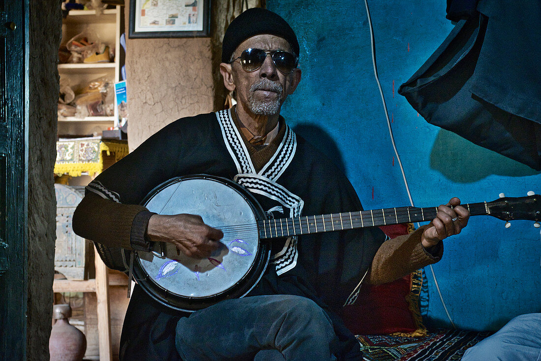 Alter blinder Mann, Berber, spielt im Museum im Dorf Oumesnat ein Instrument, Tal der Ammeln im Antiatlas, Marokko