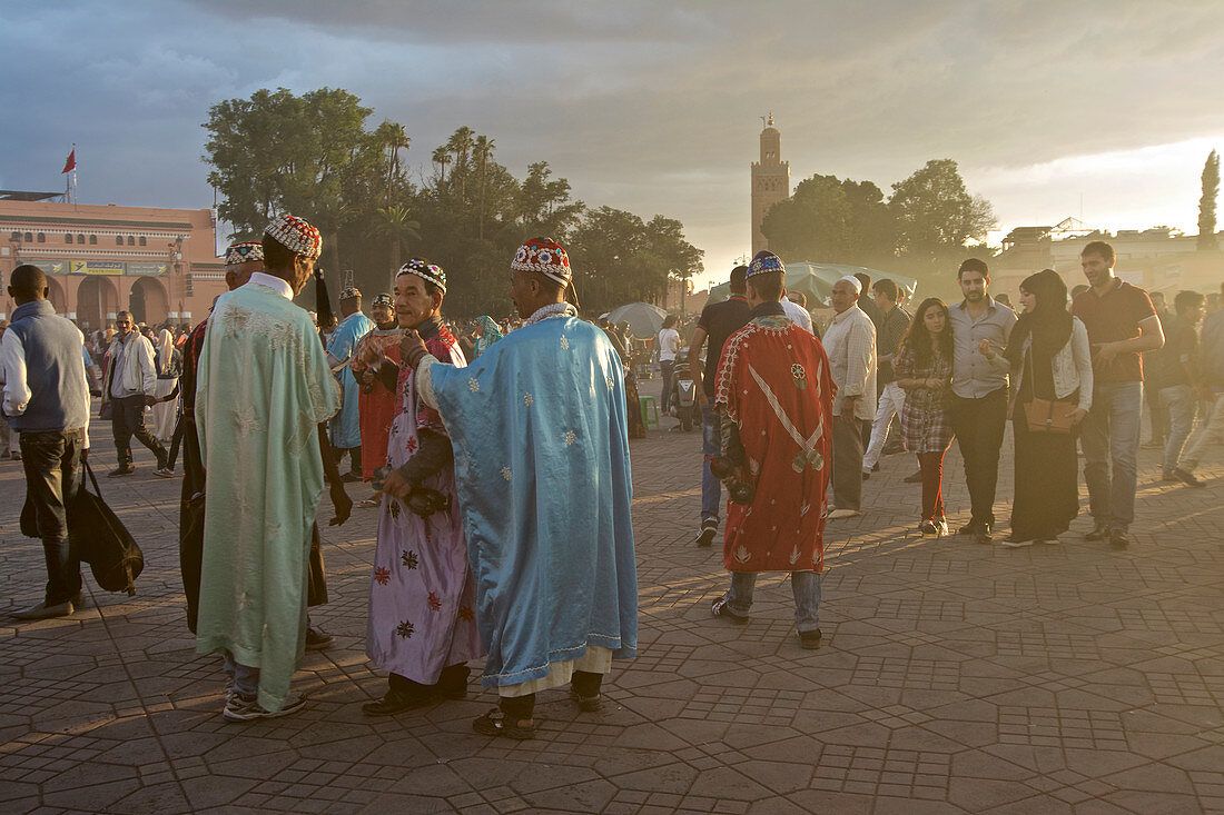 Gnaoua Musiker auf dem Jamaa el Fna vor dem Minarett der Koutoubia Moschee, Jemaa El Fna, Marrakesch, Marokko