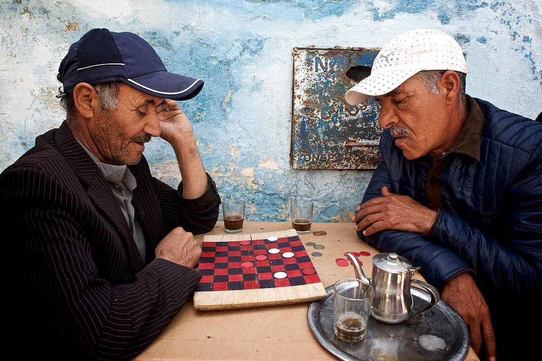 Zwei alte Männer, Marokkaner, sielen ein Brettspiel, Dame, und trinken Tee, Essaouira, Marokko