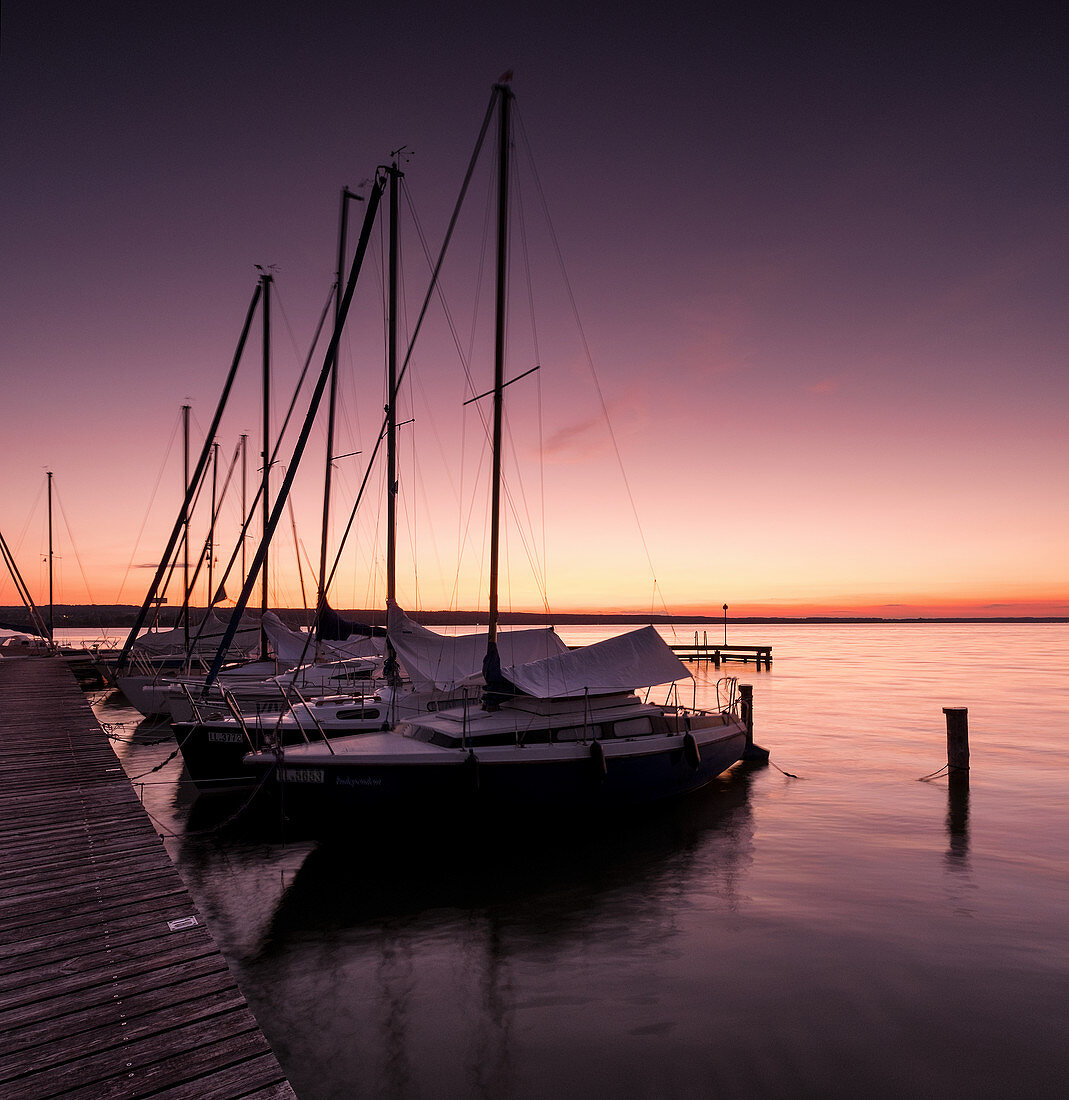 Anlegesteg mit Segelbooten bei Sonnenuntergang, Ammersee, Voralpenland, Bayern, Deutschland