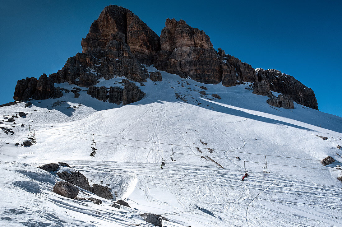 Skilift vor dem Bergmassiv der Cinque Torri im Winter, Dolomiten, Cortina d’Ampezzo, Belluno, Italien