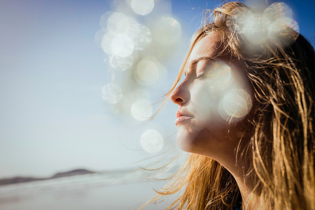 Serene woman basking in sunshine on beach