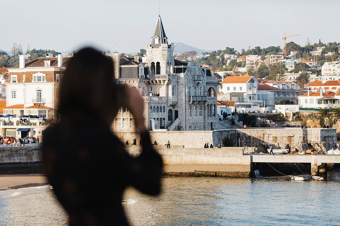 Silhouette female tourist photographing architecture, Cascais, Lisbon, Portugal