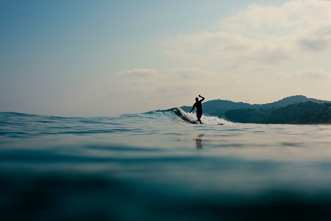 Surfer riding ocean wave, Sayulita, Nayarit, Mexico