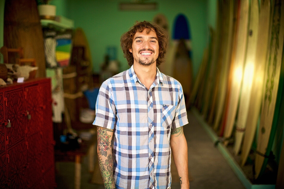 Portrait confident, happy male surf shop owner