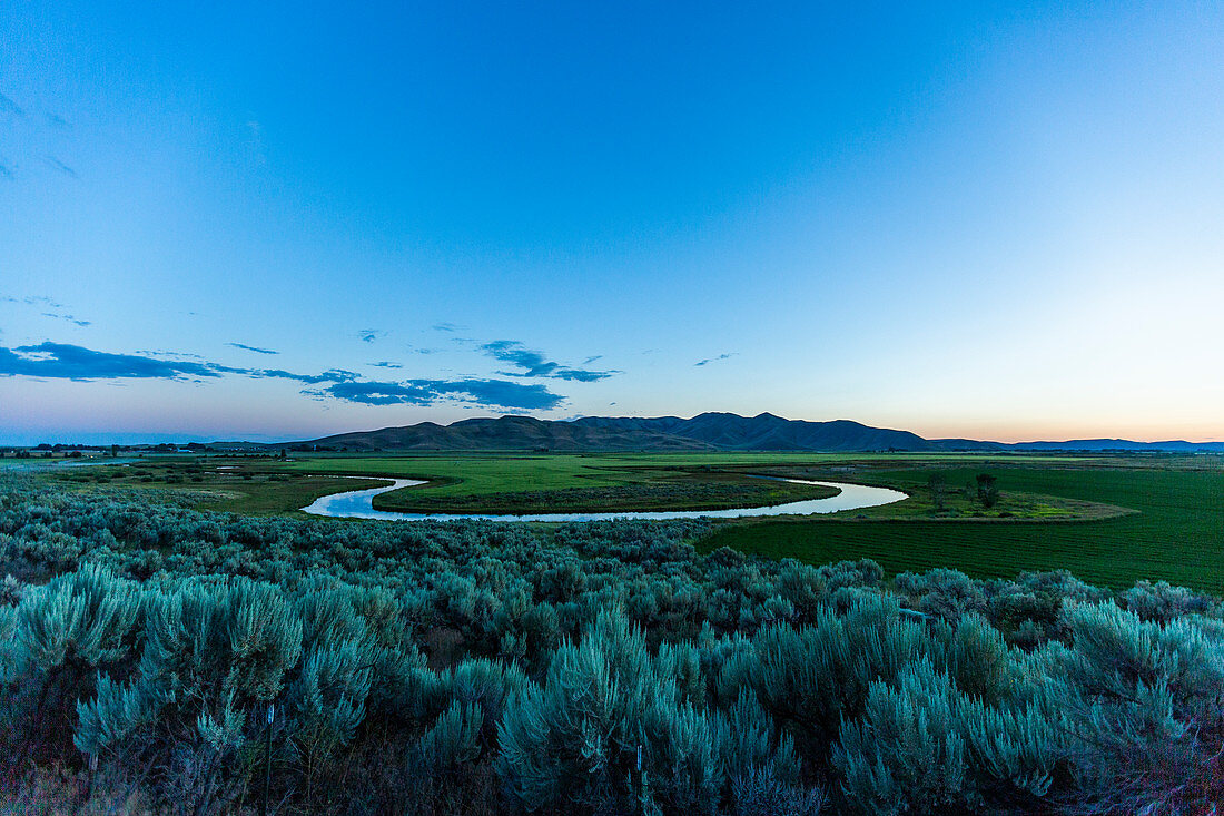 River in field at sunset in Picabo, Idaho, USA