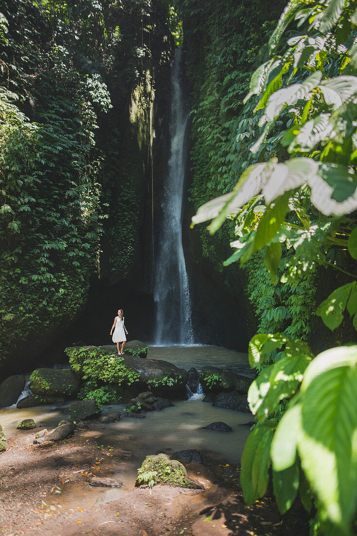 Frau am Wasserfall auf Bali, Indonesien