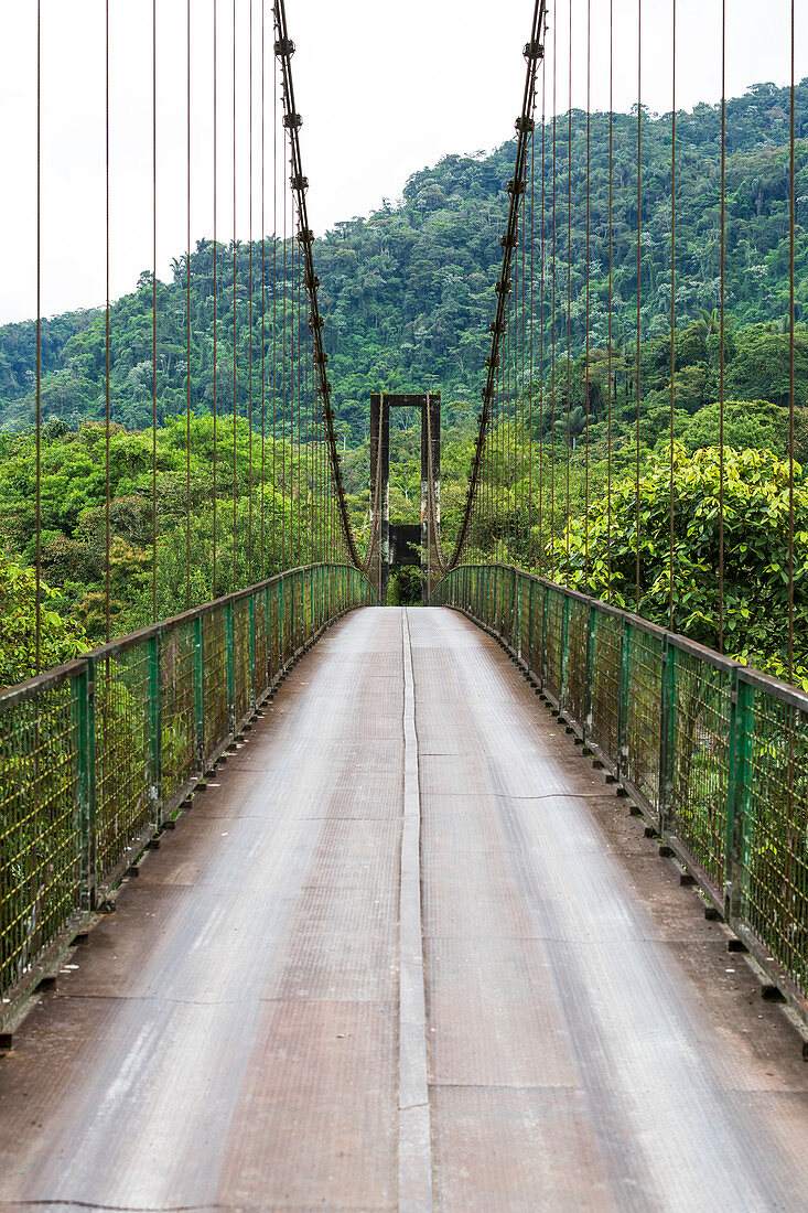 An adventurously narrow bridge over the Pastaza River near Baños, Ecuador. The bridge is approved for cars