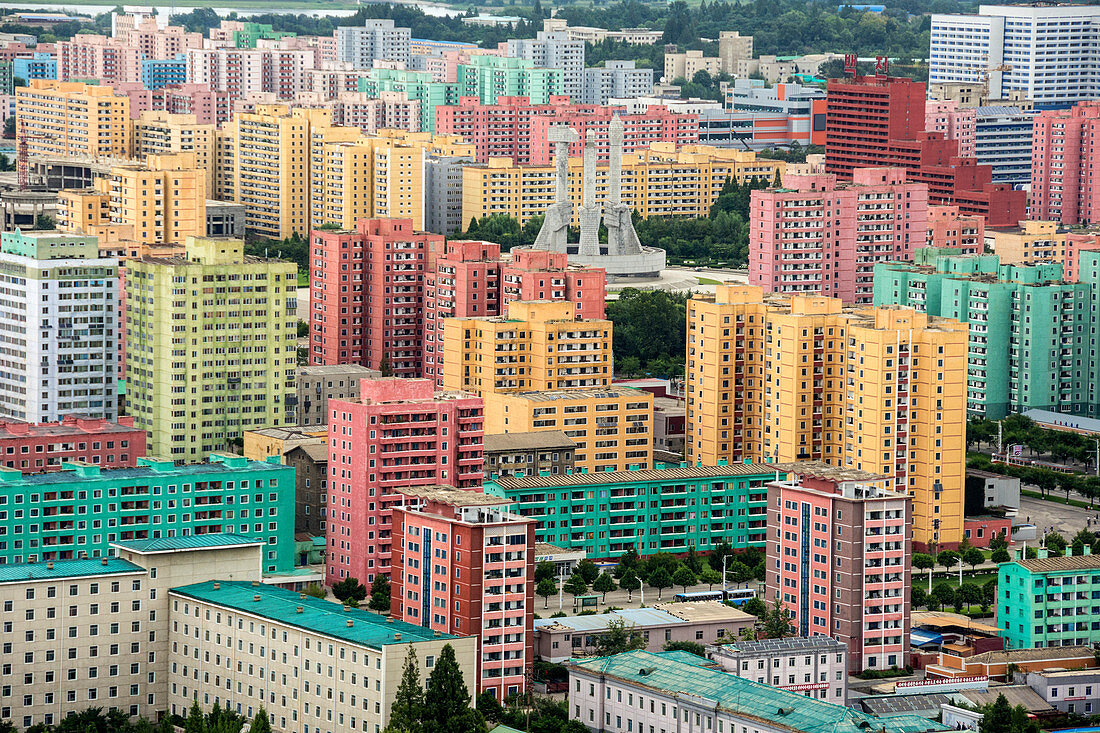 Arbeiterpartei-Denkmal inmitten gemalter Wohnblöcke, gesehen vom Juche-Turm, Pjöngjang, Nordkorea, Asien