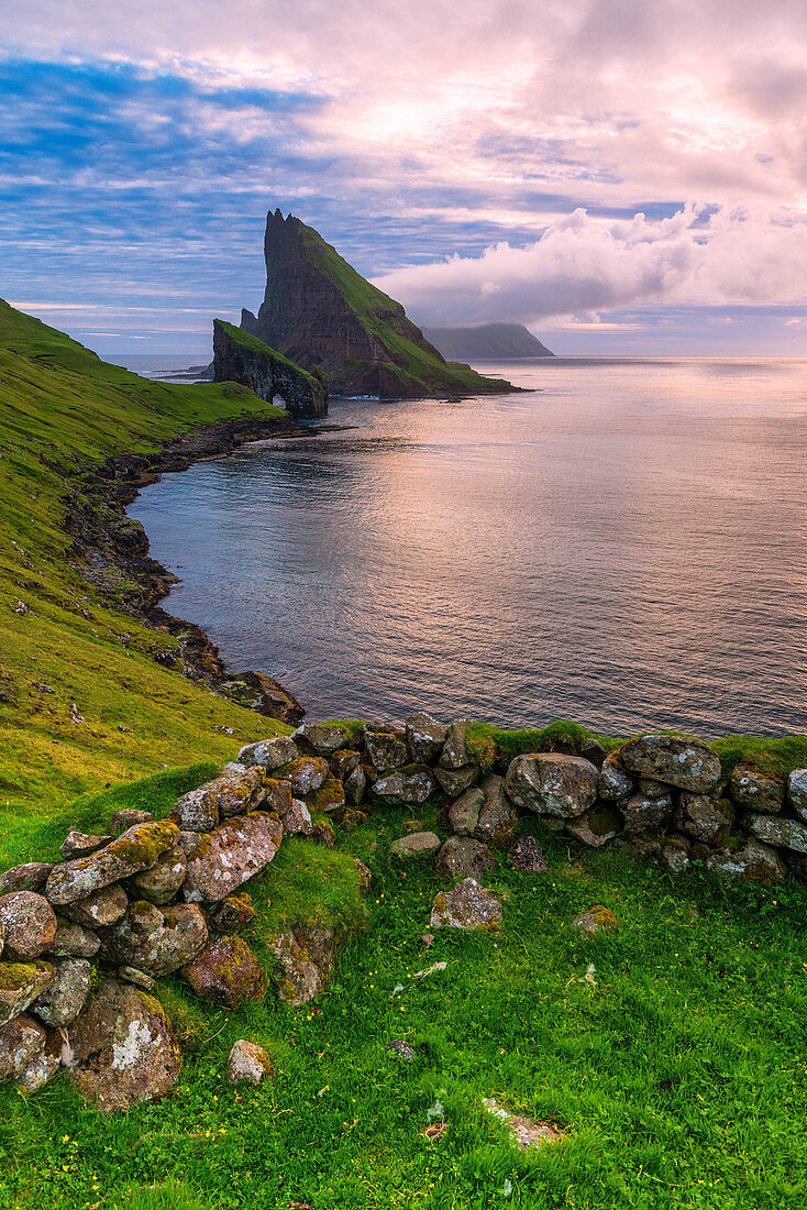 Sonnenuntergang auf dem ruhigen Ozean und Drangarnir-Felsen, Vagar-Insel, Färöer, Dänemark, Europa