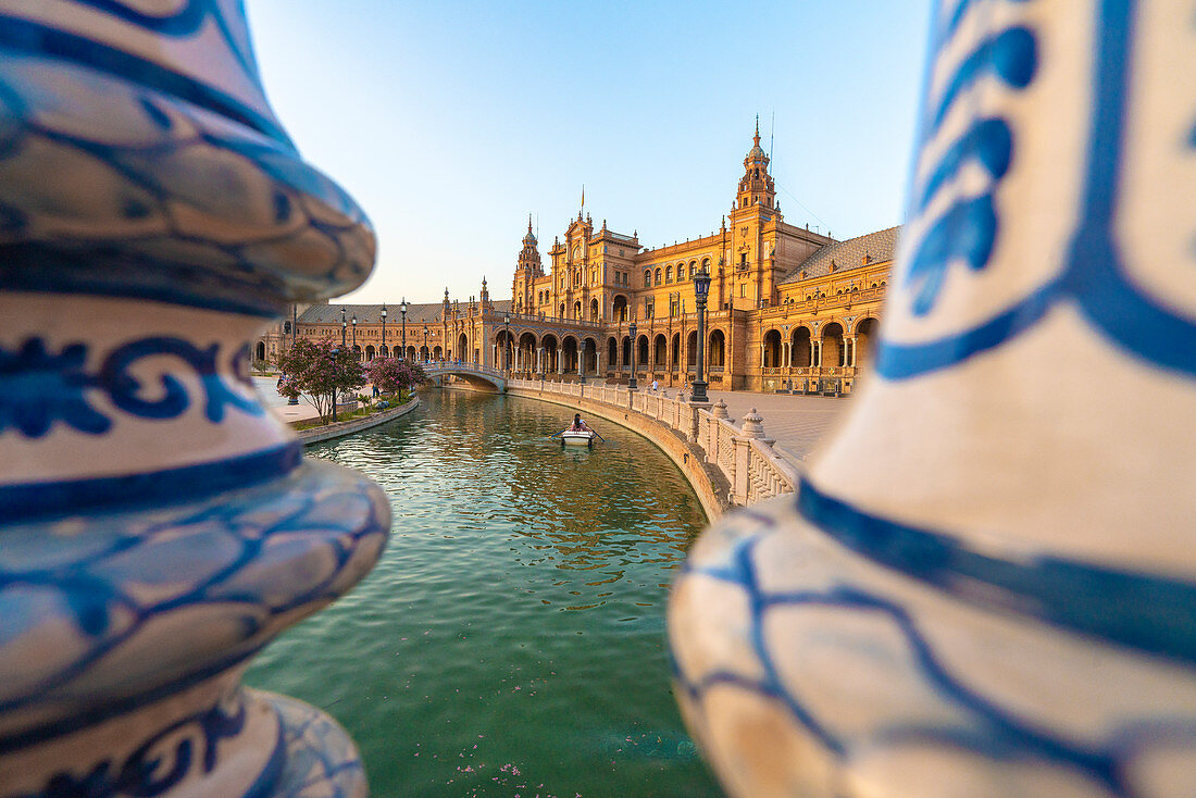 Ruderboot entlang dem Kanal gesehen durch keramischen verzierten Säulen der Balustrade, Plaza de Espana, Sevilla, Andalusien, Spanien, Europa