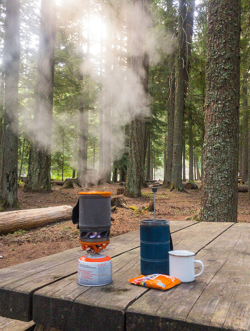 Dampf aus dem Campingkocher, der auf einem Holztisch im Mount Hood National Forest, Oregon, USA