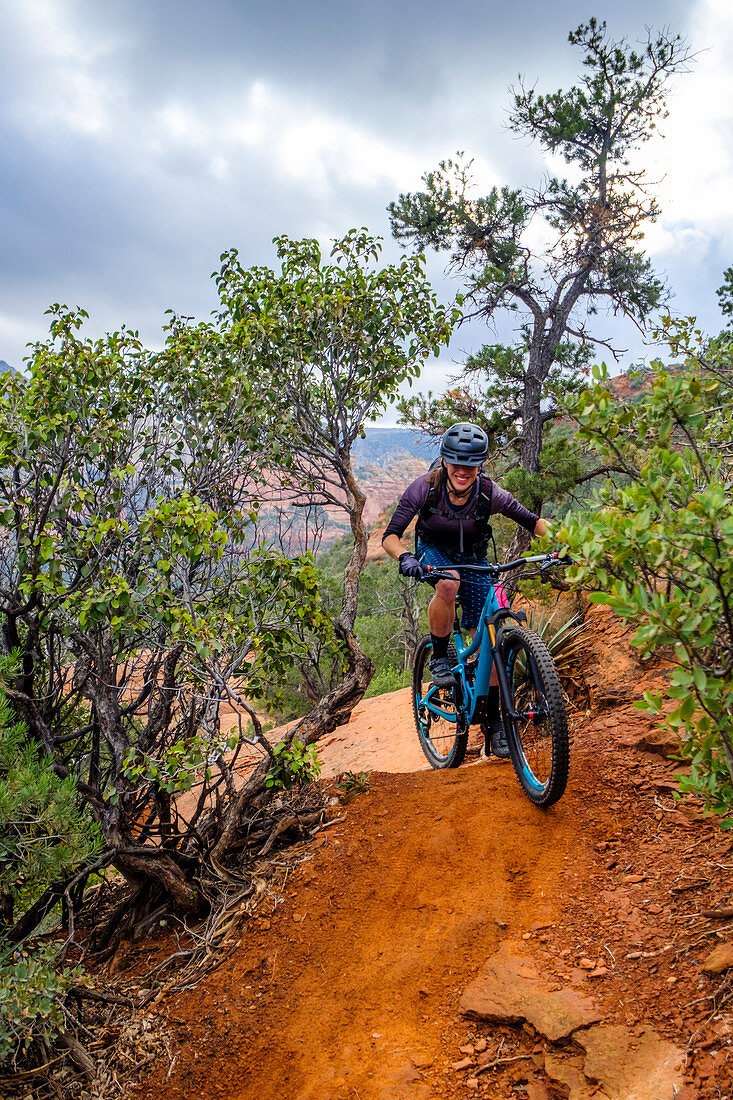 Female mountain biker riding along dirt trail, Sedona, Arizona, USA
