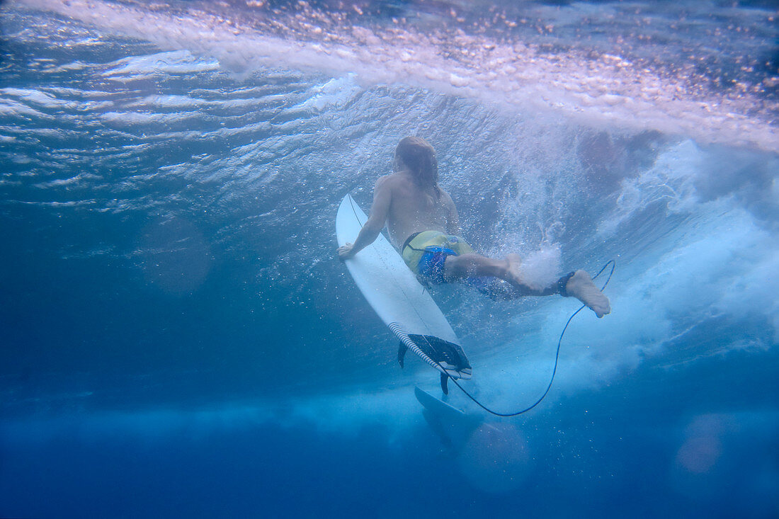 Underwater view of male surfer diving in ocean, Male, Maldives