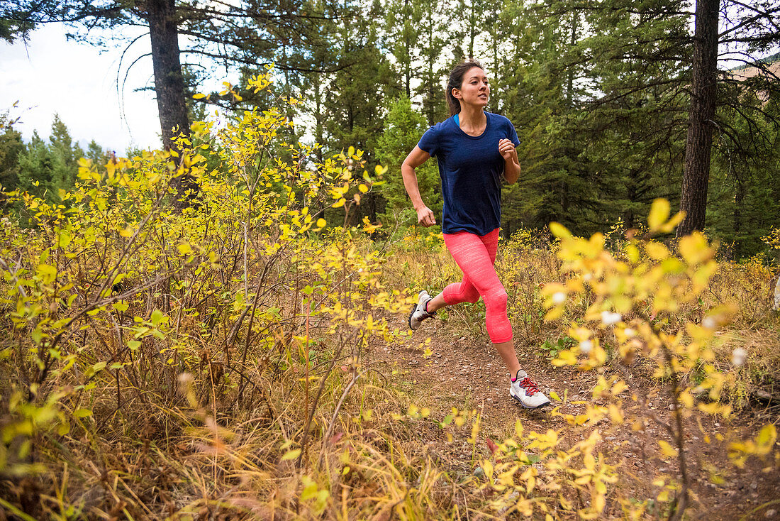 Junge Frau im Wald im Herbst, Jackson, Wyoming, USA