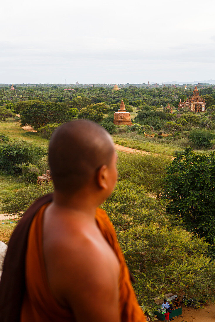 Buddhist monk looking at temples of Bagan, Mandalay Region, Myanmar. The area has over 2, 000 ancient temples and is one of the most popular tourist destinations in Myanmar.