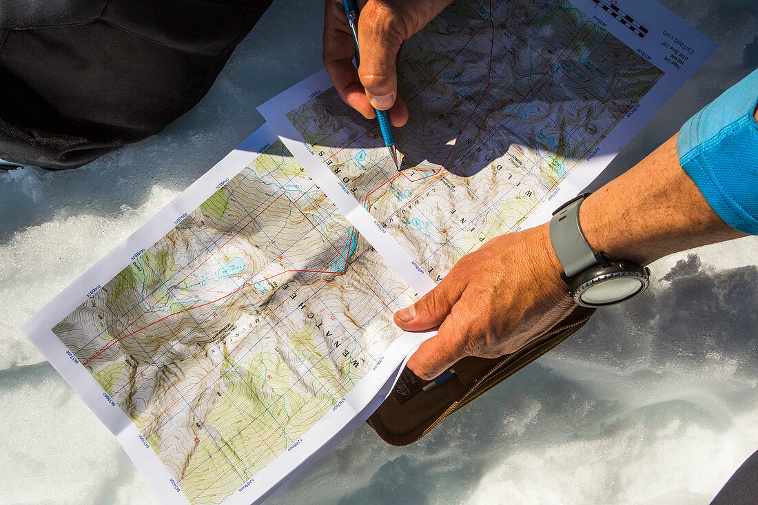 Hands of man holding map and planning ski route, Leavenworth, Washington, USA